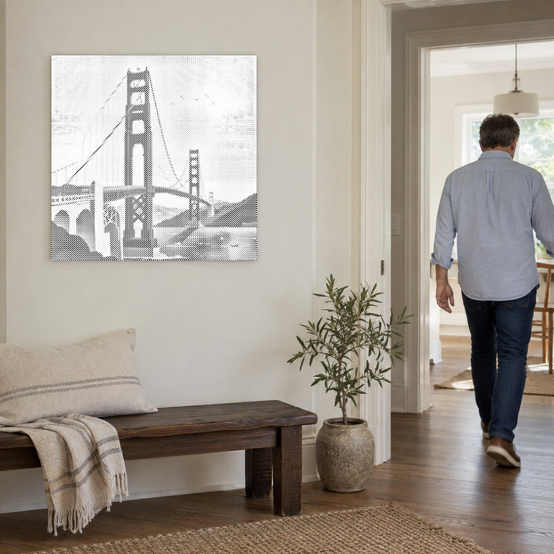 Prickmålningen “Golden Gate Bridge”, på en ljus vägg med en person som går genom dörren intill.