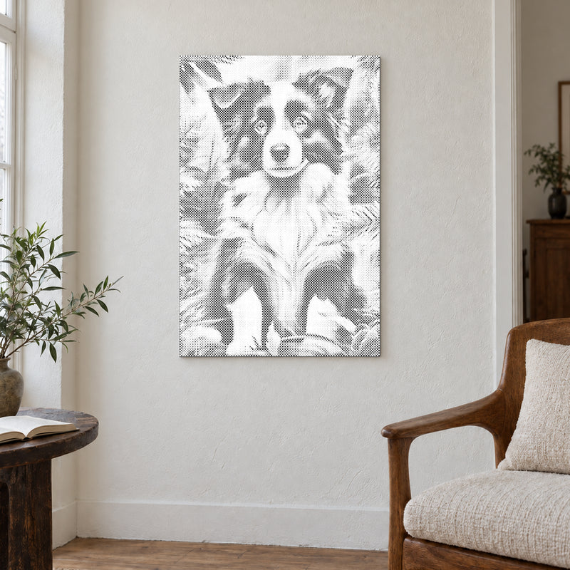 Prickmålningen “Border collie valp”, på en ljus vägg i ett rum med mjukt dagsljus.