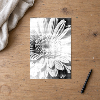 Prickmålningen “Gerbera blomma”, sedd ovanifrån på ett arbetsbord i mjukt dagsljus.