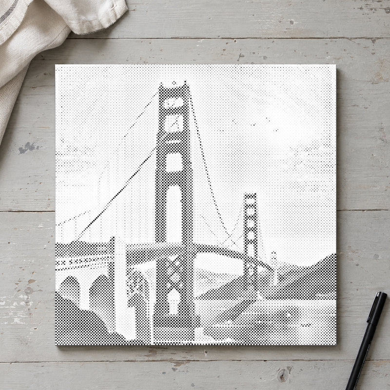 Prickmålningen “Golden Gate Bridge”, sedd ovanifrån på ett arbetsbord i mjukt dagsljus.