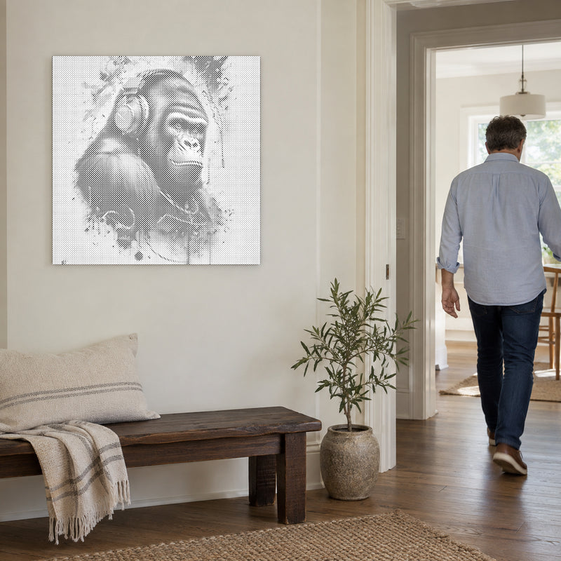 Prickmålningen “Gorilla med hörlurar”, på en ljus vägg med en person som går genom dörren intill.