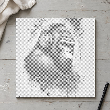 Prickmålningen “Gorilla med hörlurar”, sedd ovanifrån på ett arbetsbord i mjukt dagsljus.