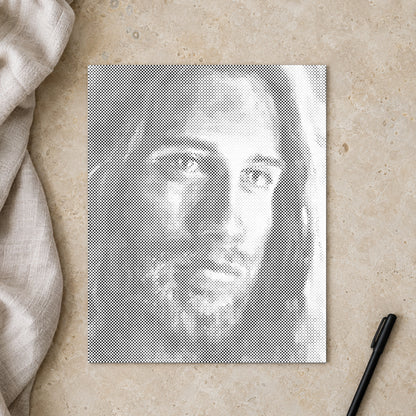 Prickmålningen “Jesus kristus”, sedd ovanifrån på ett arbetsbord i mjukt dagsljus.