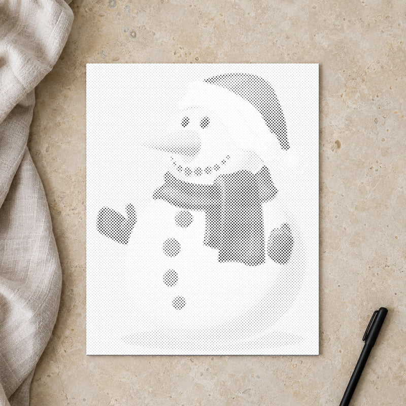 Prickmålningen “Snögubbe”, sedd ovanifrån på ett arbetsbord i mjukt dagsljus.